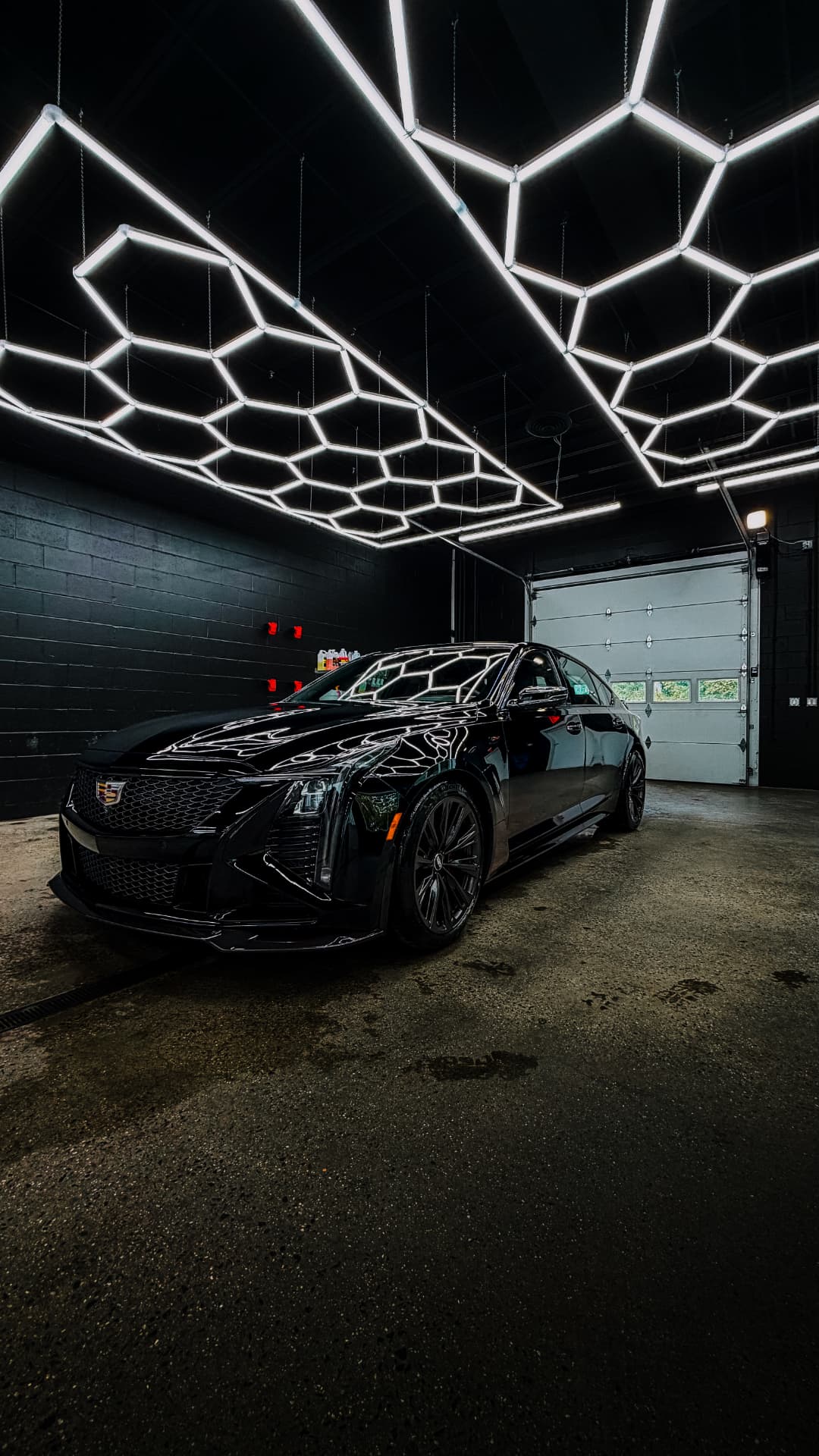 Blacked-out Cadillac CT5-V detailed to a mirror finish under hexagon studio lighting